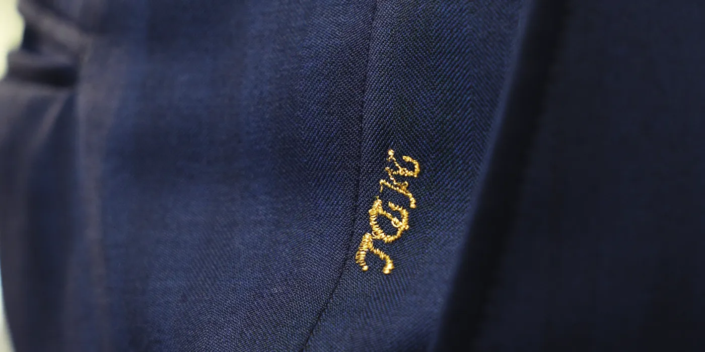 Gold monogram embroidered above the trouser pocket
