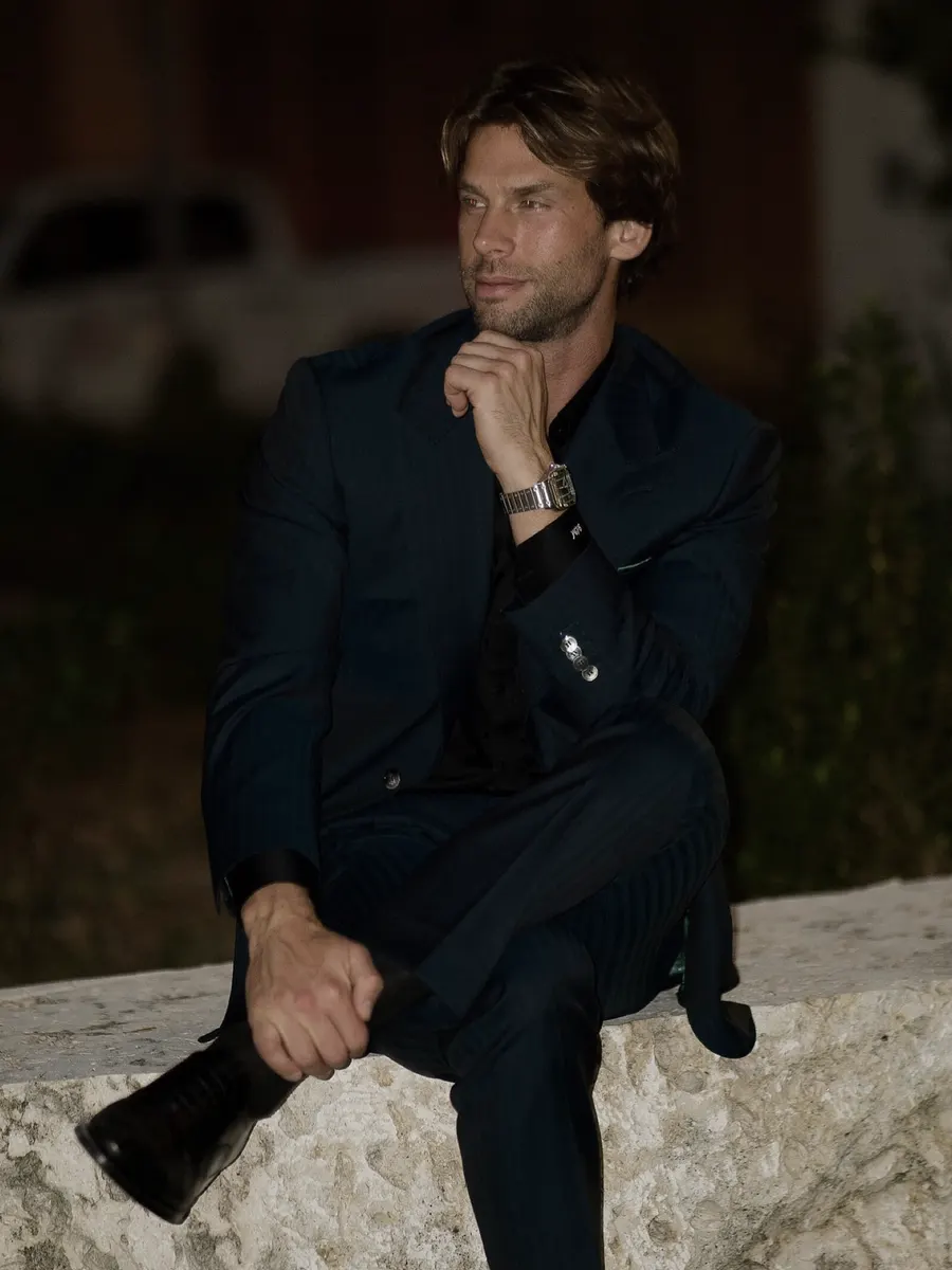 Seated at night in a navy suit